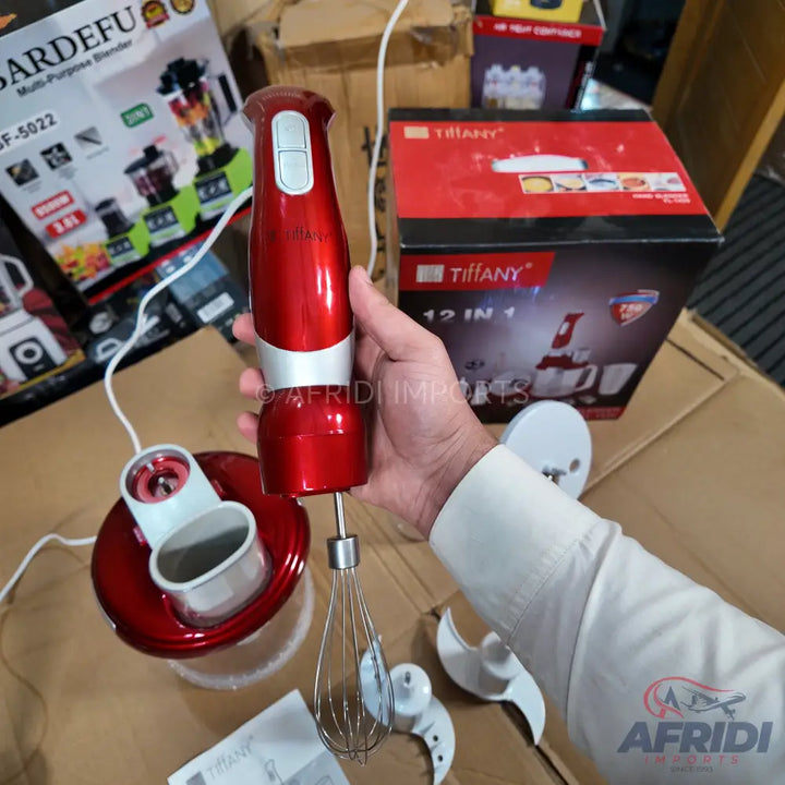 A red and silver handheld immersion blender with multiple attachments.