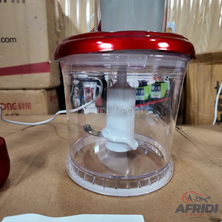 A clear plastic food processor bowl with a red lid and an internal blade assembly.