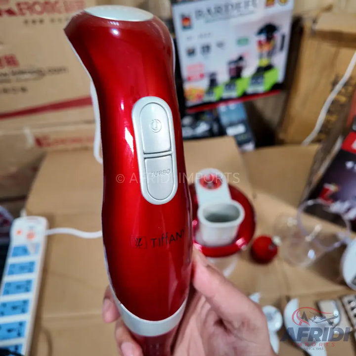 Red handheld immersion blender with two silver control buttons.