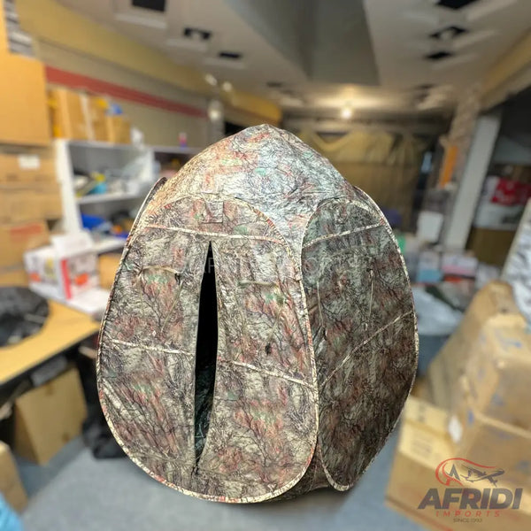 Camouflage patterned pop-up privacy tent with a zippered opening.