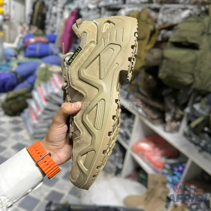 A tan-colored hiking shoe with a rugged sole and textured sides.