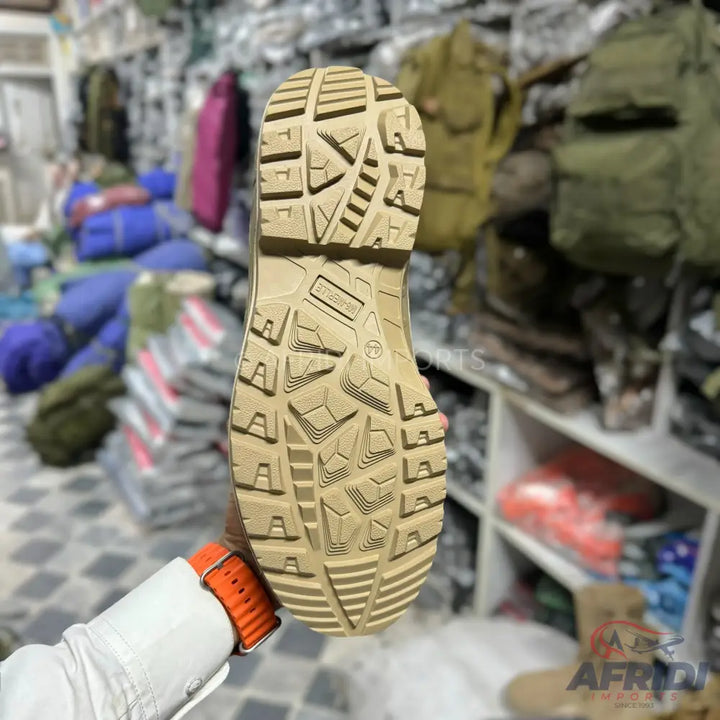 Tan combat boot sole with rugged tread.