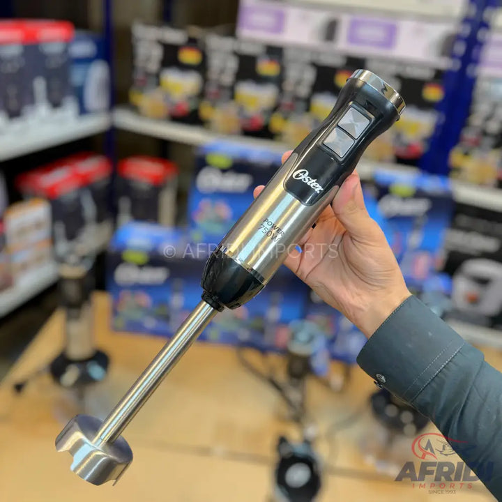 A stainless steel immersion blender with two control buttons.