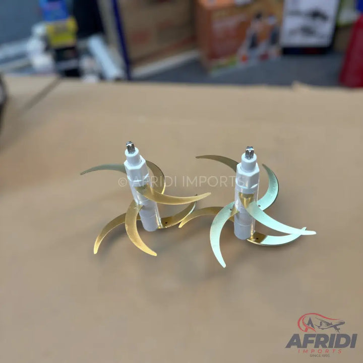 Two sets of gold-colored, curved blender blades with white plastic bases.