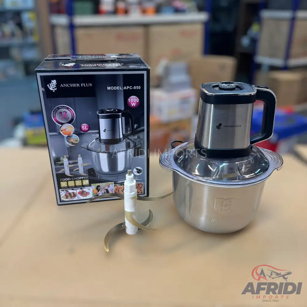 A stainless steel food chopper with a 5-liter capacity and a 1000W motor, complete with its packaging and blade attachment.