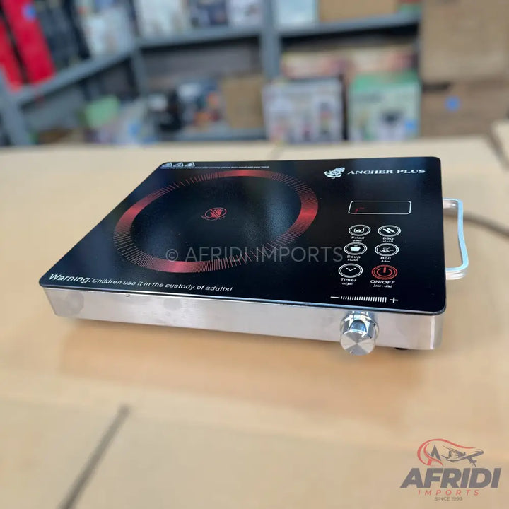 A sleek, black induction cooktop with a silver base and a single control knob, featuring a circular heating element and touch-sensitive buttons for various cooking functions.