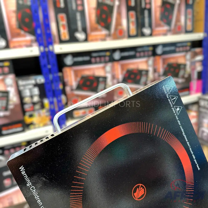 Black portable induction cooktop with a red circular heating element design.