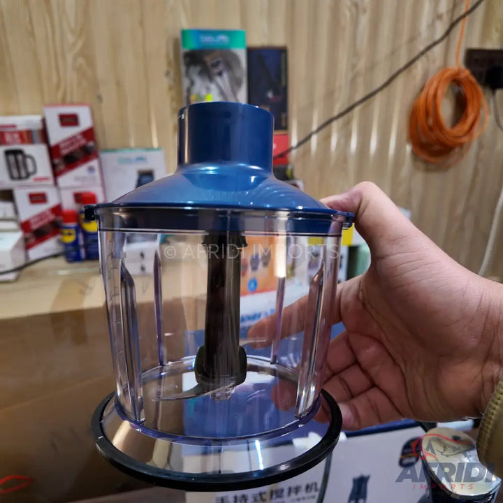 A clear plastic food chopper with a blue lid and a visible blade.