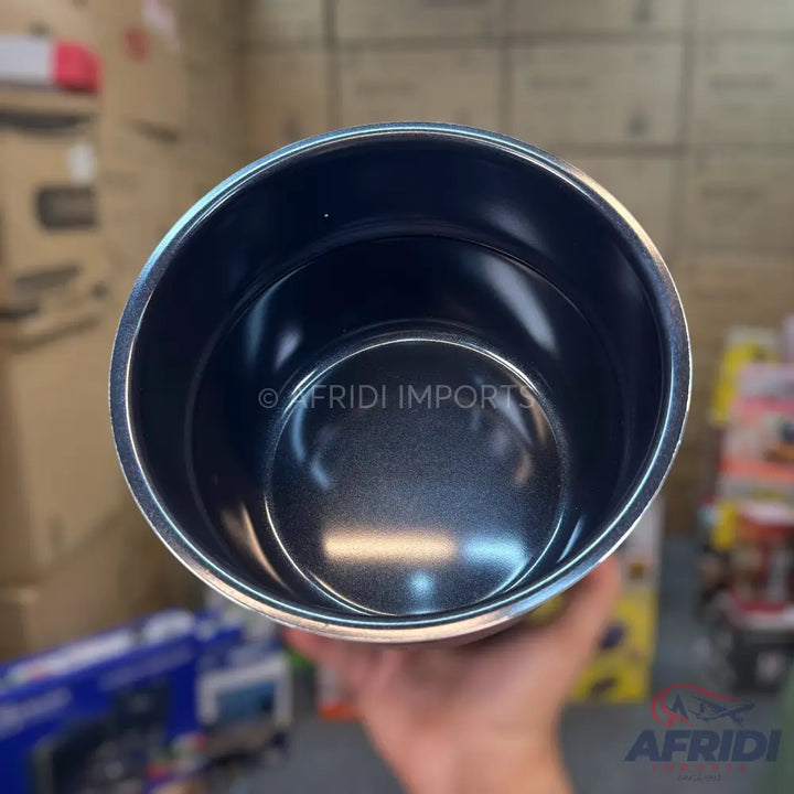 A dark-colored, empty, cylindrical container with a metallic finish.