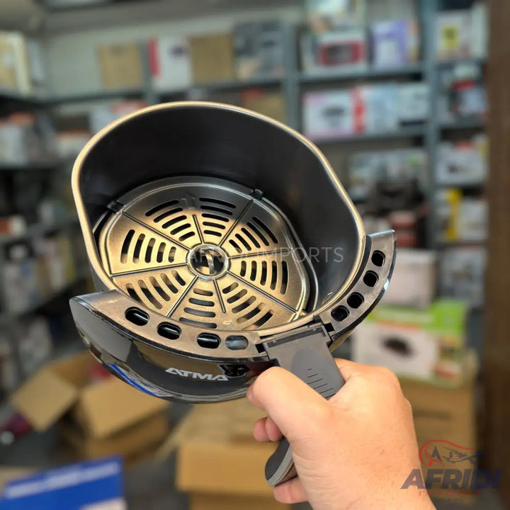 An open air fryer basket with a removable grill plate and a gray handle.