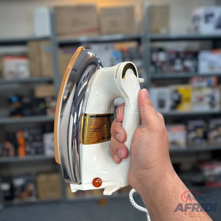 A cream-colored electric dry iron with a chrome soleplate and an orange indicator light.