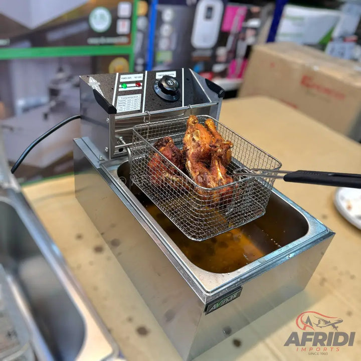 Stainless steel electric deep fryer with a basket holding fried chicken.