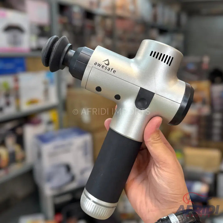A metallic silver and black percussive massage gun with a disc-shaped attachment.