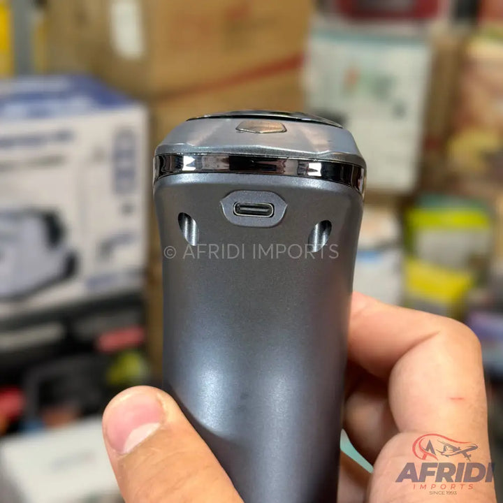 A dark grey electric shaver with a USB-C charging port.
