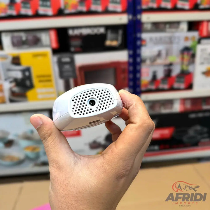 White handheld electronic device with a perforated front panel and a small lens.