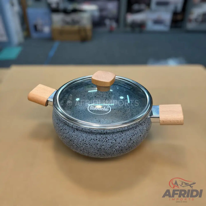 Granite-coated cooking pot with wooden handles and a glass lid.