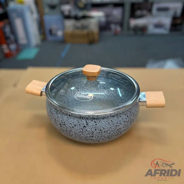 Gray speckled cooking pot with a glass lid and wooden handles.
