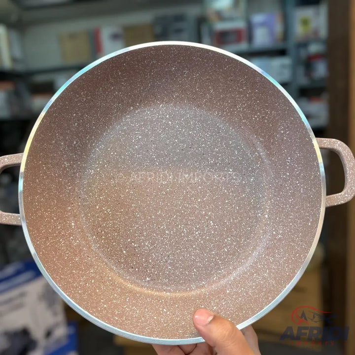 A round, light brown, speckled non-stick cooking pot with two handles.