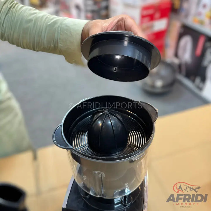 A black and transparent electric citrus juicer with a removable reamer and pulp filter.