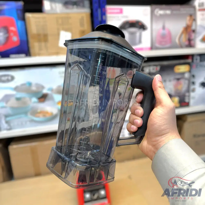 A dark grey transparent blender jar with a black handle and lid.