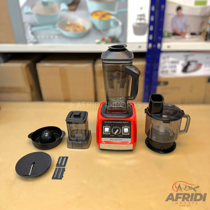 A red multi-function kitchen blender with various attachments, including a large blending jar, a smaller chopper, and a food processor bowl with interchangeable blades.