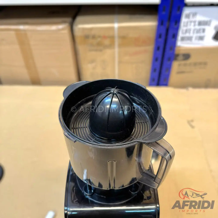 A black electric citrus juicer with a reamer and a clear pitcher.
