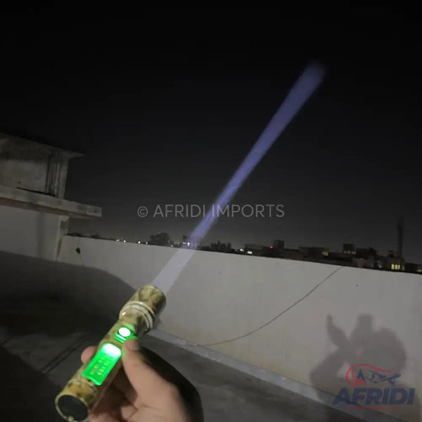 A gold and black flashlight with a glowing green display, emitting a bright blue beam of light.