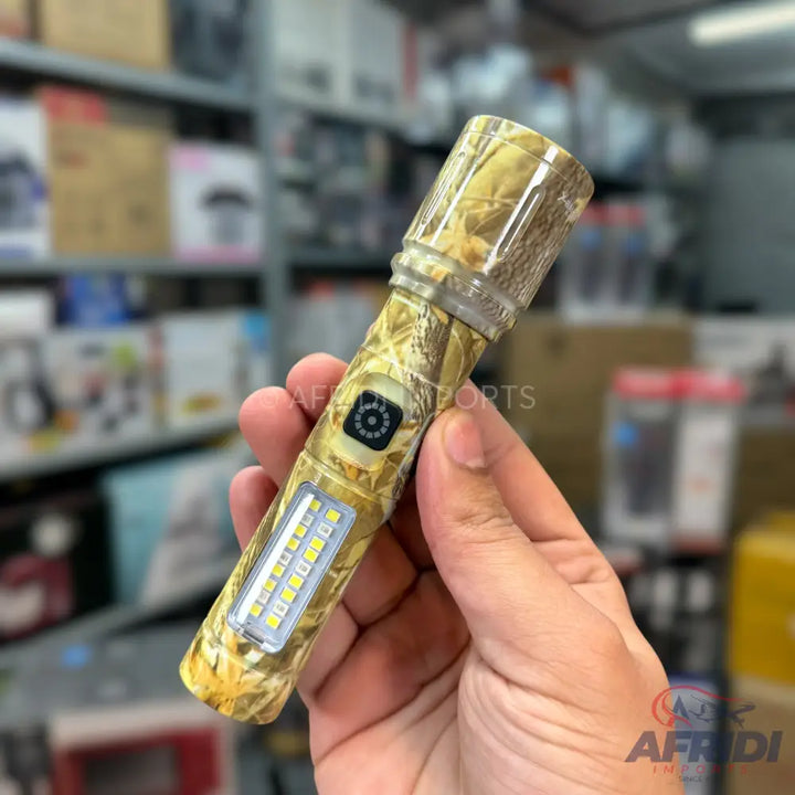 Camo-patterned flashlight with a side panel of LED lights and a small, circular button.