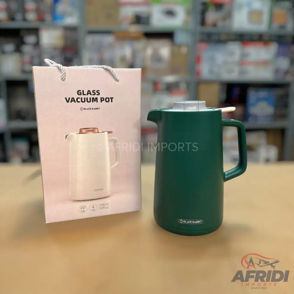 A dark green thermal carafe with a handle and white lid, designed to keep liquids hot or cold.