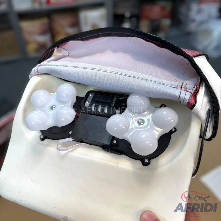 A white and black electronic massager with four rotating nodes on each of two massage heads.