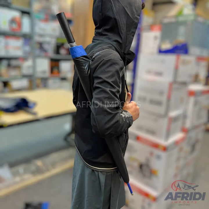 A black umbrella with a blue accent, carried on a person’s back.