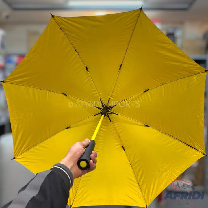 A bright yellow umbrella with a black handle.