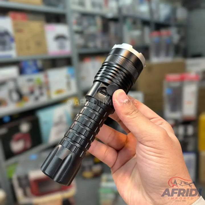 Black metallic flashlight with a ribbed grip and a side power button.