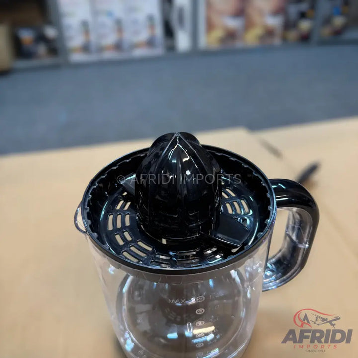 A black and clear plastic citrus juicer with a measurement scale.