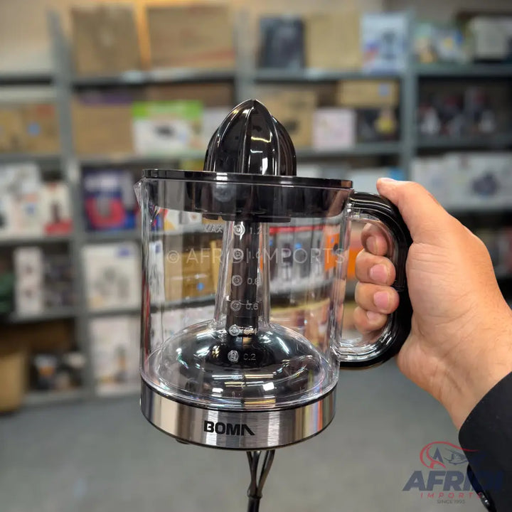 A clear electric citrus juicer with a black reamer and a silver base.