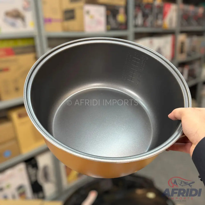 Gold-colored rice cooker pot with a non-stick interior and measurement markings.