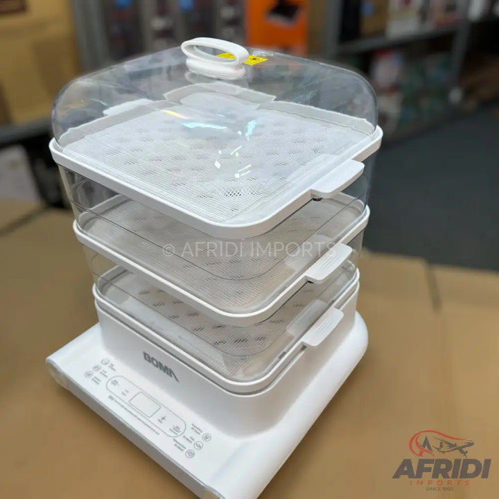 White, three-tiered electric food steamer with clear plastic trays.