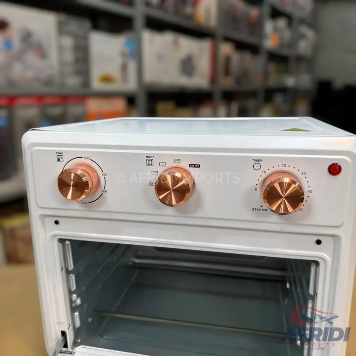 White electric oven with three copper-colored control knobs and a glass door.