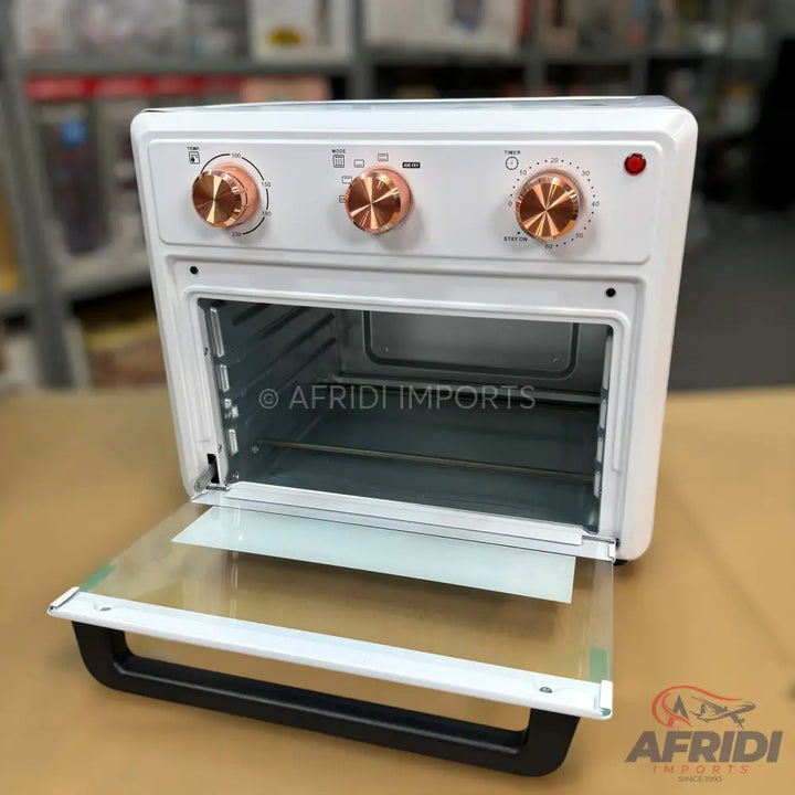 White toaster oven with rose gold control knobs and an open glass door.