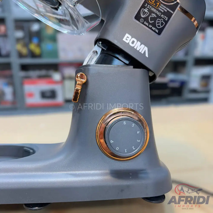 A grey stand mixer with a copper-colored speed dial and a shiny copper-colored lever.