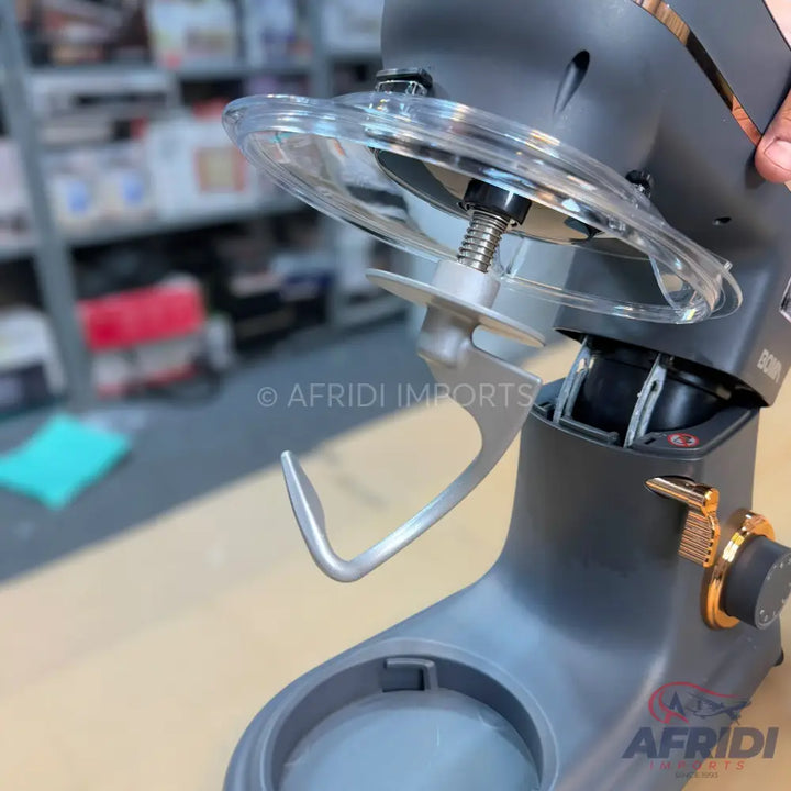 A stand mixer with a clear splash guard and dough hook attachment.