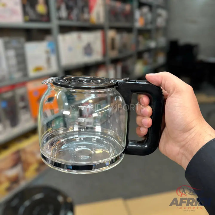 Clear glass coffee carafe with a black handle and lid.