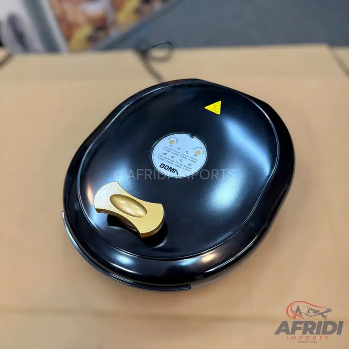 Black electric waffle maker with a gold-colored handle.