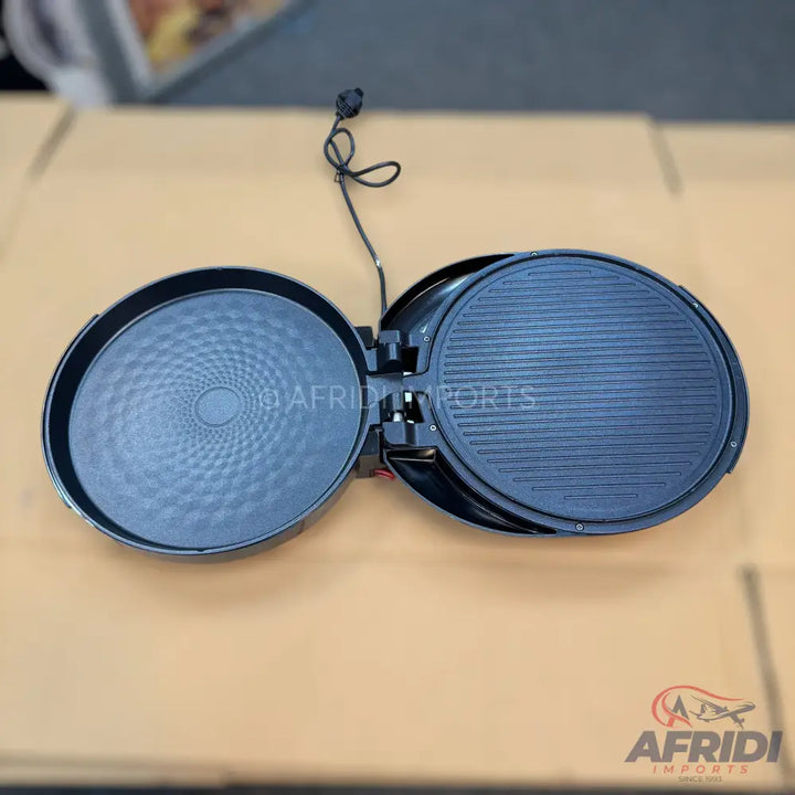 An open electric griddle with two round cooking plates, one with a textured pattern and the other with parallel ridges, connected by a hinge and a power cord.