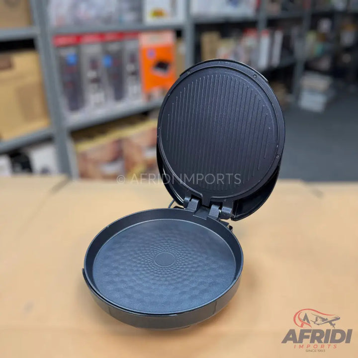 An open, round, black electric griddle with a ribbed upper plate and a textured lower plate.