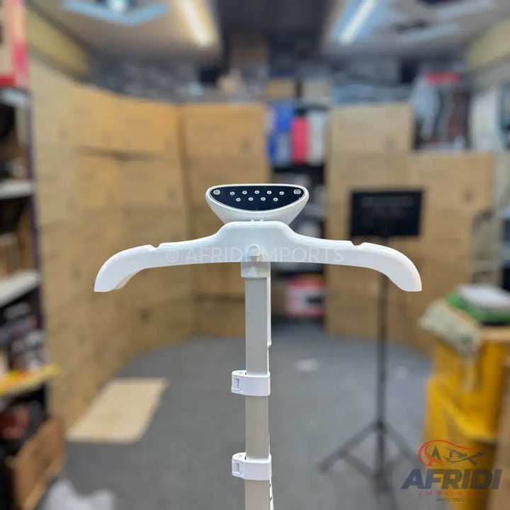 White garment steamer with an adjustable stand and integrated hanger.