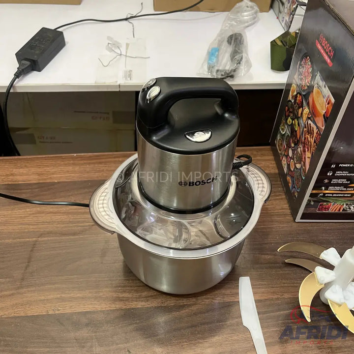 Stainless steel electric food chopper with a black handle.