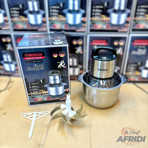 Stainless steel Bosch food chopper with a black handle, an extra set of blades, and a whisk attachment.