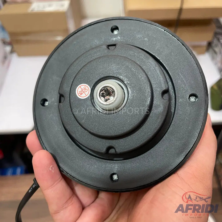 The underside of a black electric kettle base, featuring a central power connector and screw holes.