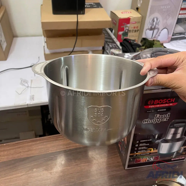 Stainless steel food chopper bowl with a handle.